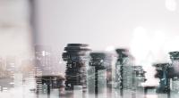 Collage image of stacks of coins and office skyline.
